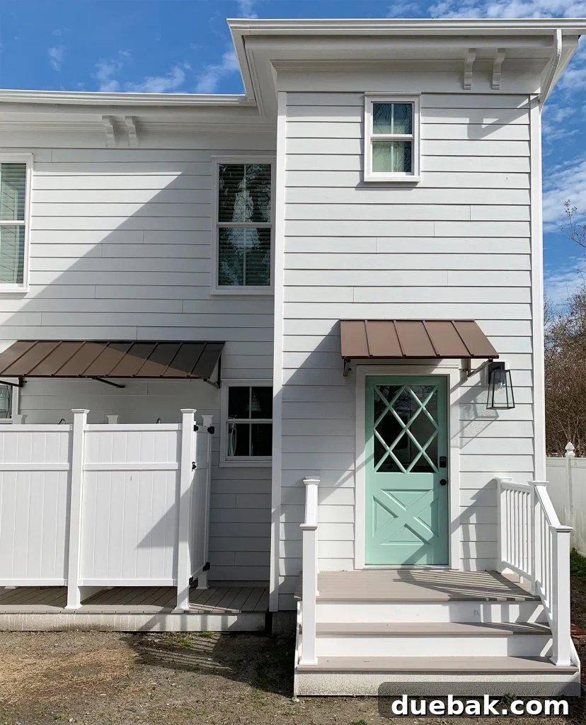 Completed rear exterior of the south side of the duplex after renovation, showcasing diamond doors, awnings, and outdoor showers