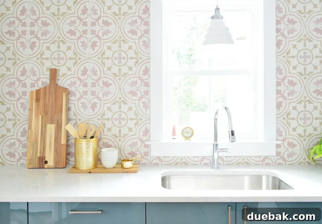 Pink Patterned Tile Backsplash With White Counters and Blue Cabinets