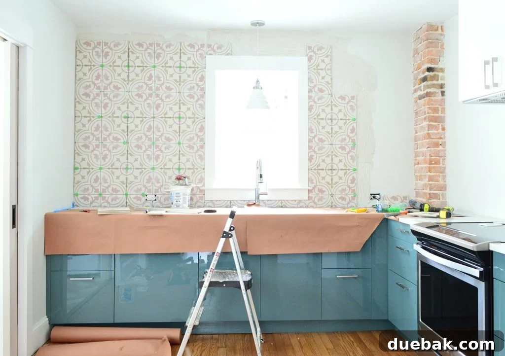 Pink Patterned Backsplash Tile in Blue Kitchen, Mostly Completed Installation