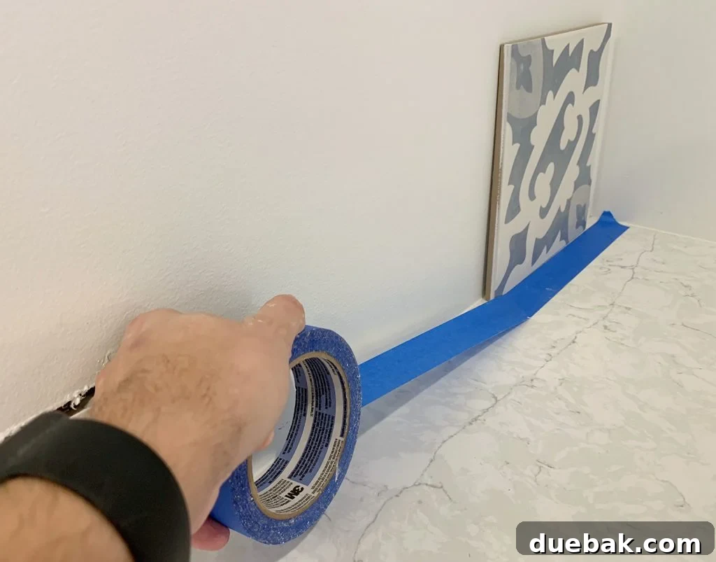 Taping Off Counter with Blue Painter's Tape Before Backsplash Installation
