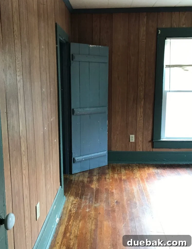 Our Airbnb Bedroom and Bathroom Makeover Full Reveal 12 Before shot of the front bedroom, showing a blue closet door and a covered window, hinting at hidden potential for transformation.