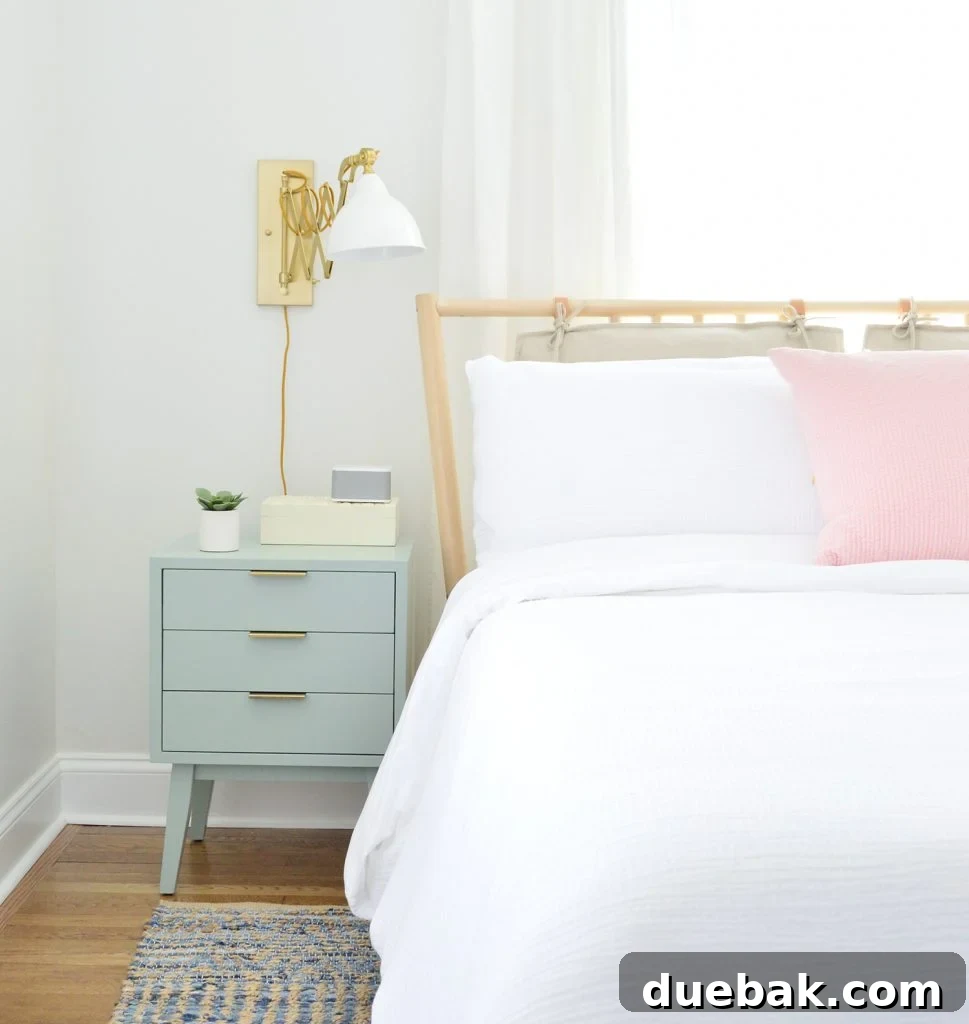 Our Airbnb Bedroom and Bathroom Makeover Full Reveal 16 Close-up of a nightstand with a sound machine and a wall-mounted sconce, adding both function and style to the bedroom.