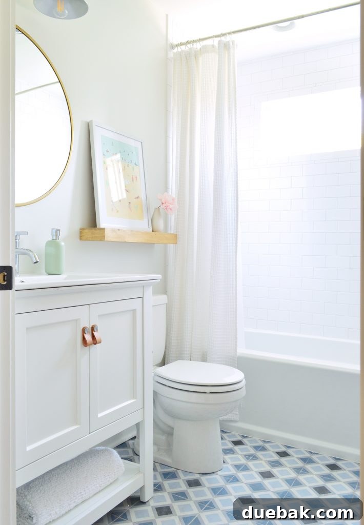 Our Airbnb Bedroom and Bathroom Makeover Full Reveal 19 Hall bathroom on the left side, featuring a unique patterned floor tile, a clean white vanity, and cohesive design elements.