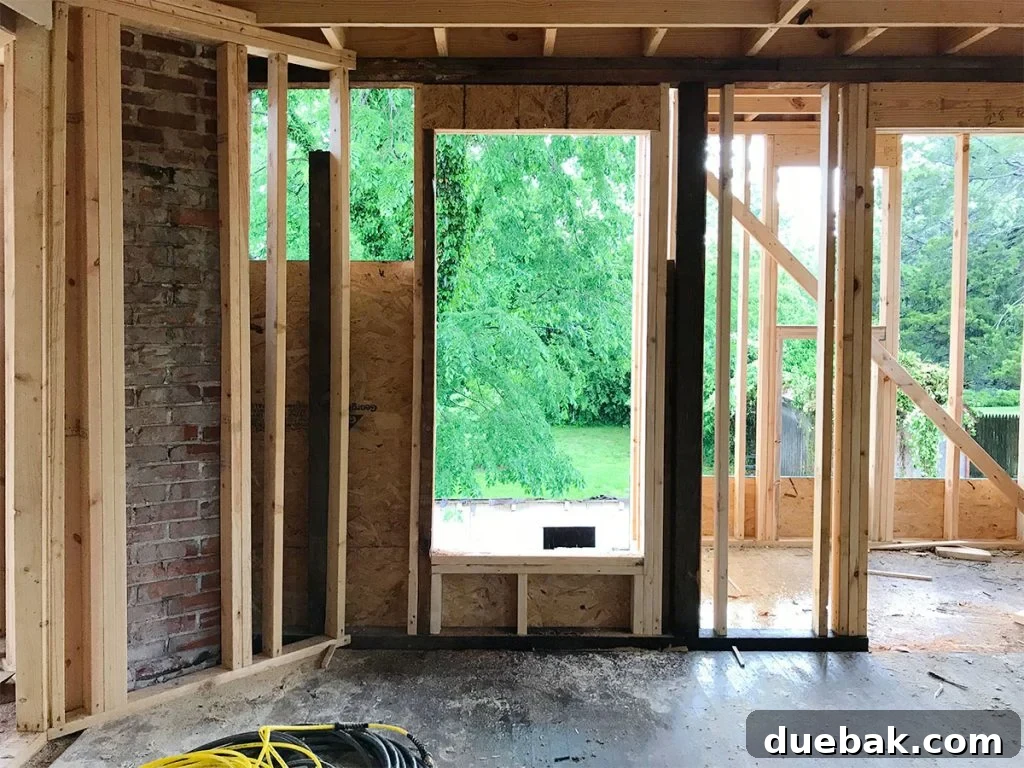 Our Airbnb Bedroom and Bathroom Makeover Full Reveal 3 The main bedroom during renovation, showing the framing of a newly added window, revealing the transformation.