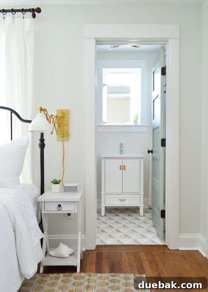 Our Airbnb Bedroom and Bathroom Makeover Full Reveal 5 Ensuite bathroom in the duplex, featuring a modern white vanity, circular mirror, and cohesive design elements.