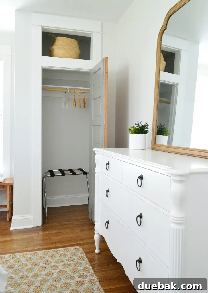 Our Airbnb Bedroom and Bathroom Makeover Full Reveal 9 Bedroom view showcasing a stylish dresser with a large mirror, practical storage baskets, and a textured rug.