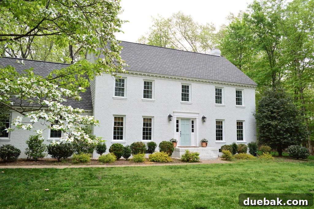 White painted brick house in spring with flowering dogwoods