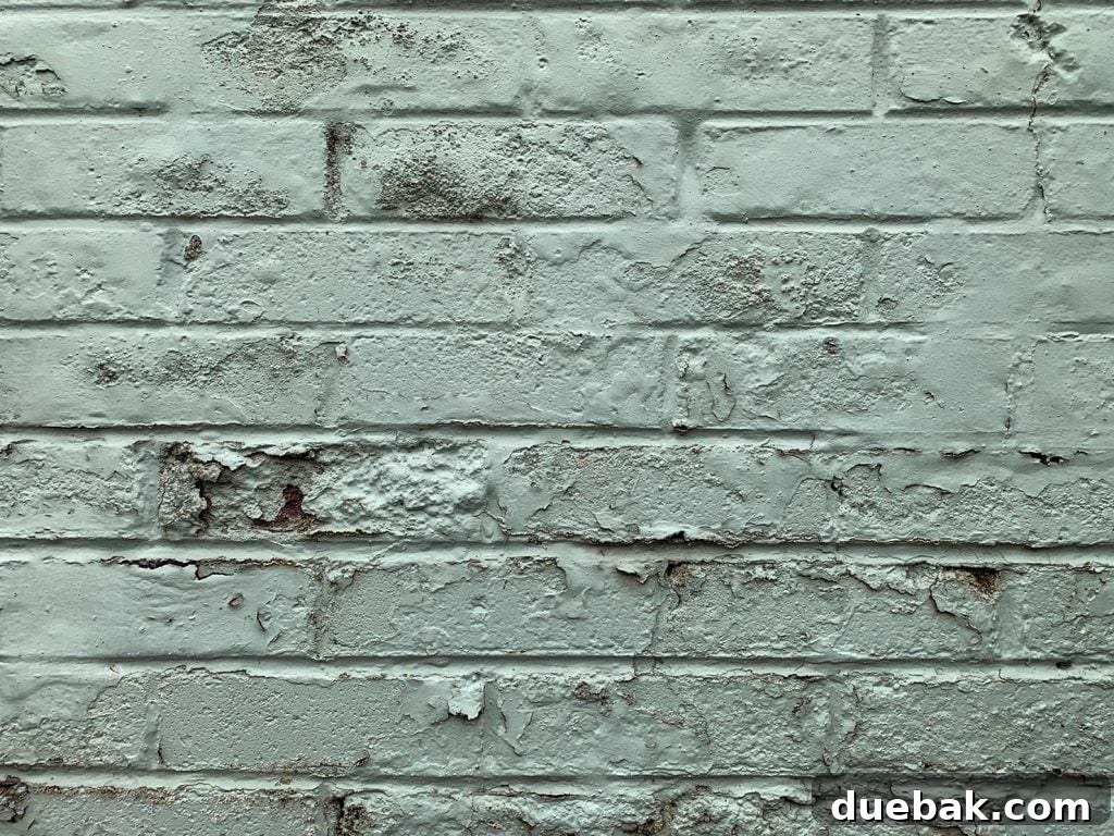Cracking and peeling paint on a brick wall, illustrating improper paint use