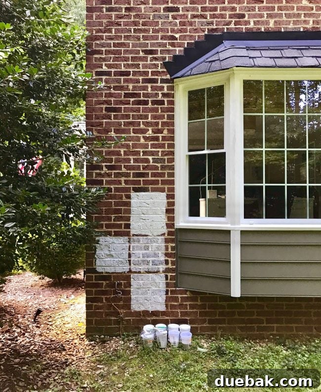 Sample sections of white paint on a brick house