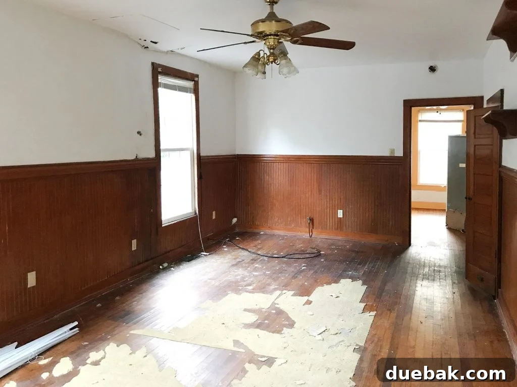 Dual Kitchen Transformations: Our Airbnb's Story 4 Before photo of the duplex interior, showing a living room looking into a dimly lit space with orange trim.