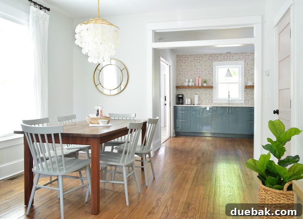 Dual Kitchen Transformations: Our Airbnb's Story 6 Bright dining room with a capiz chandelier looking into a pink and blue modern kitchen.
