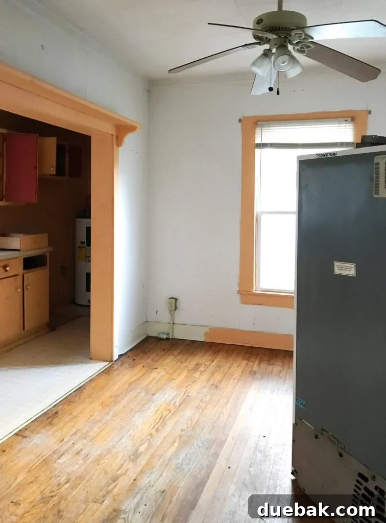 Dual Kitchen Transformations: Our Airbnb's Story 7 Before photo of a large yellow room, previously a dining area, with an old fridge in the middle.