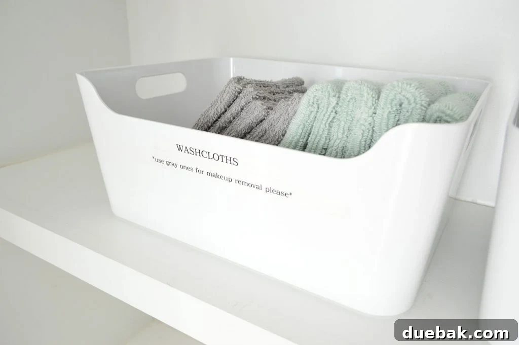 Duplex hallway linen closet with a Target bin label, showing organized washcloths.