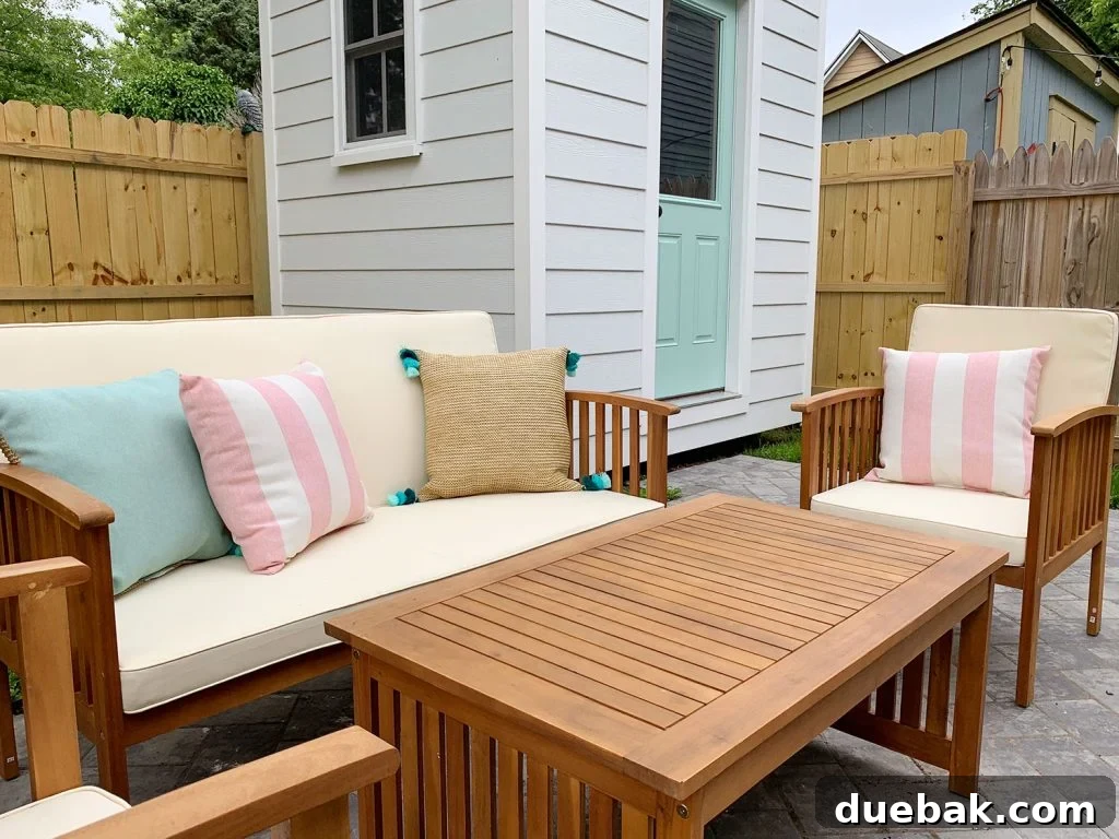 Panoramic view of one side of the duplex backyard, showcasing the shed, outdoor furniture, string lights, and paver path, designed for optimal guest experience.