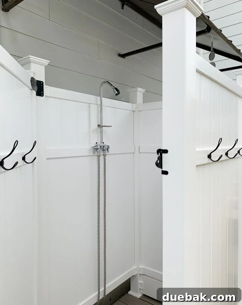 Inside view of the outdoor shower showing the robust privacy wall with an extra board at the bottom for enhanced seclusion and guest comfort.