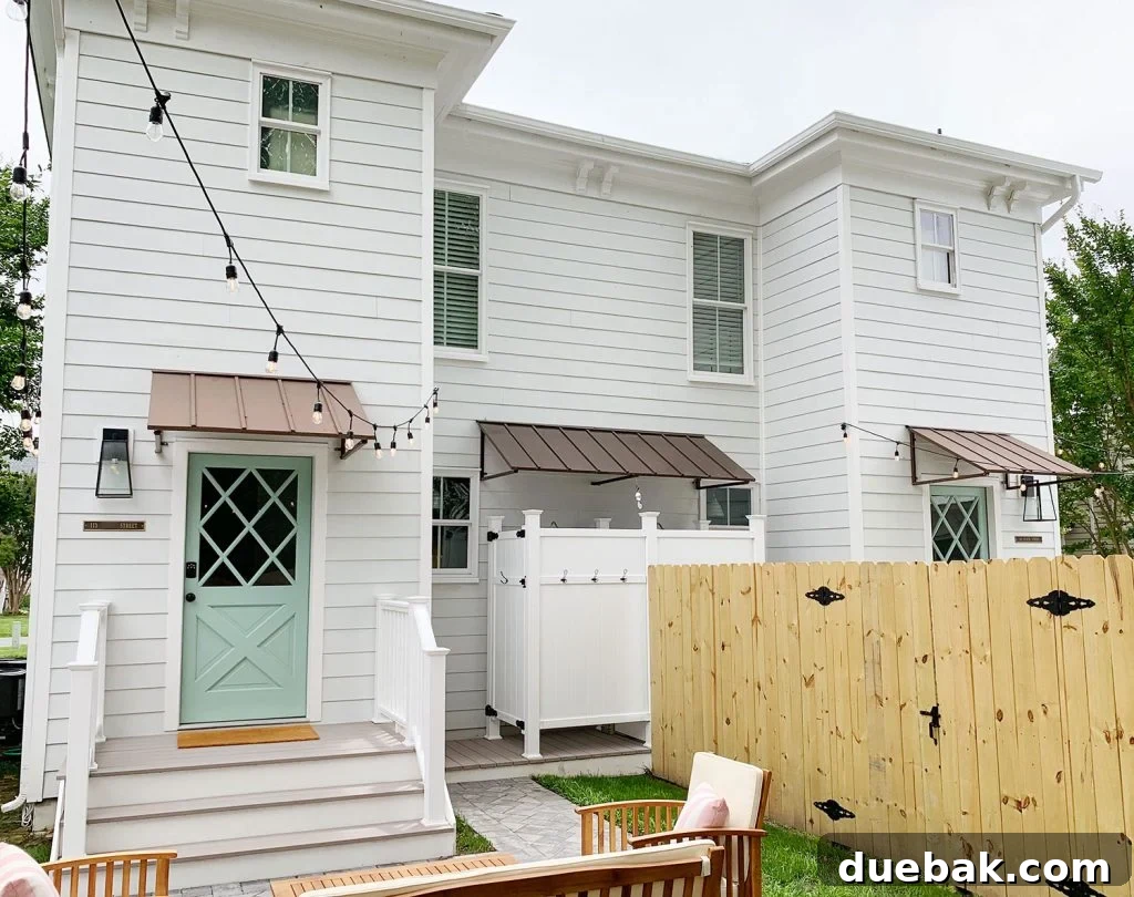 Wide view of the duplex backyards, showcasing the mirror-image layout and the effective dividing 6-foot privacy fence, designed for optimal guest privacy.