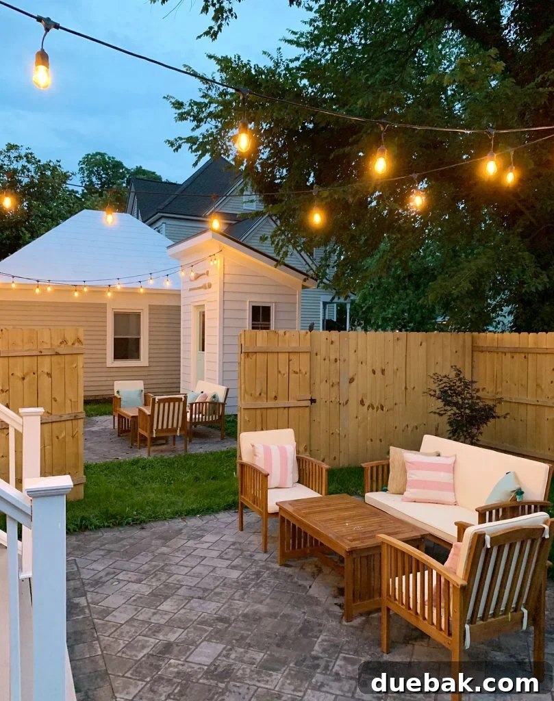 Cozy evening view of the duplex backyard with beautifully illuminated string lights, comfortable outdoor seating, and a warm, inviting ambiance.