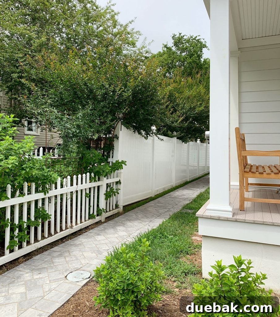 Left side of the duplex backyard path, elegantly lined with crepe myrtles and vibrant greenery, leading to the main outdoor space.