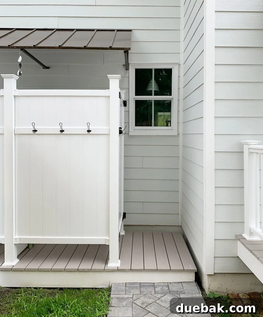 White railings on the duplex back steps seamlessly integrate with the nearby outdoor shower design, creating a cohesive aesthetic.