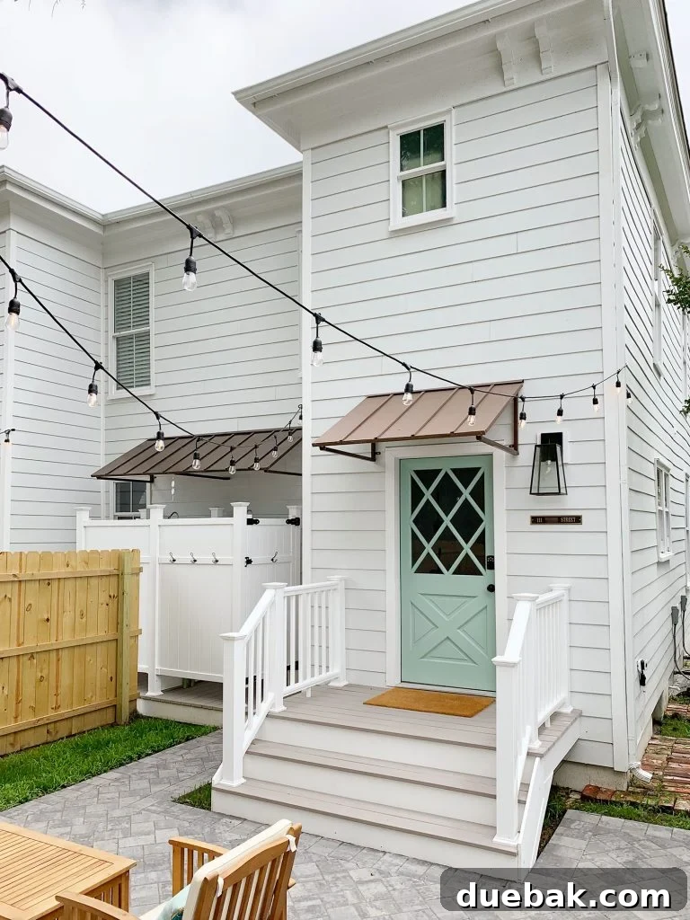 Wide back steps of the duplex leading to the yard, featuring a porch lantern, address plaque, and keypad lock, emphasizing spacious and welcoming design.