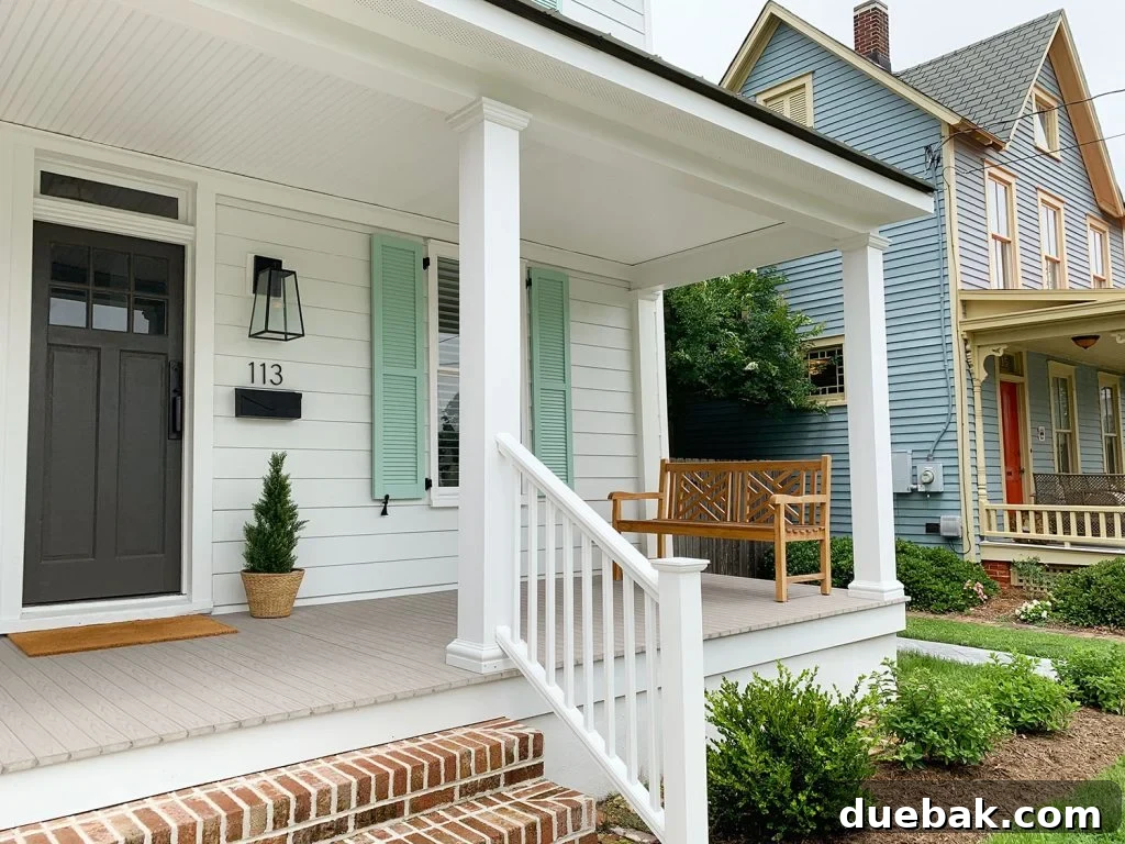 Front view of the duplex showcasing new landscaping, prominent house numbers, elegant porch lanterns, and comfortable benches, adding to its overall appeal.