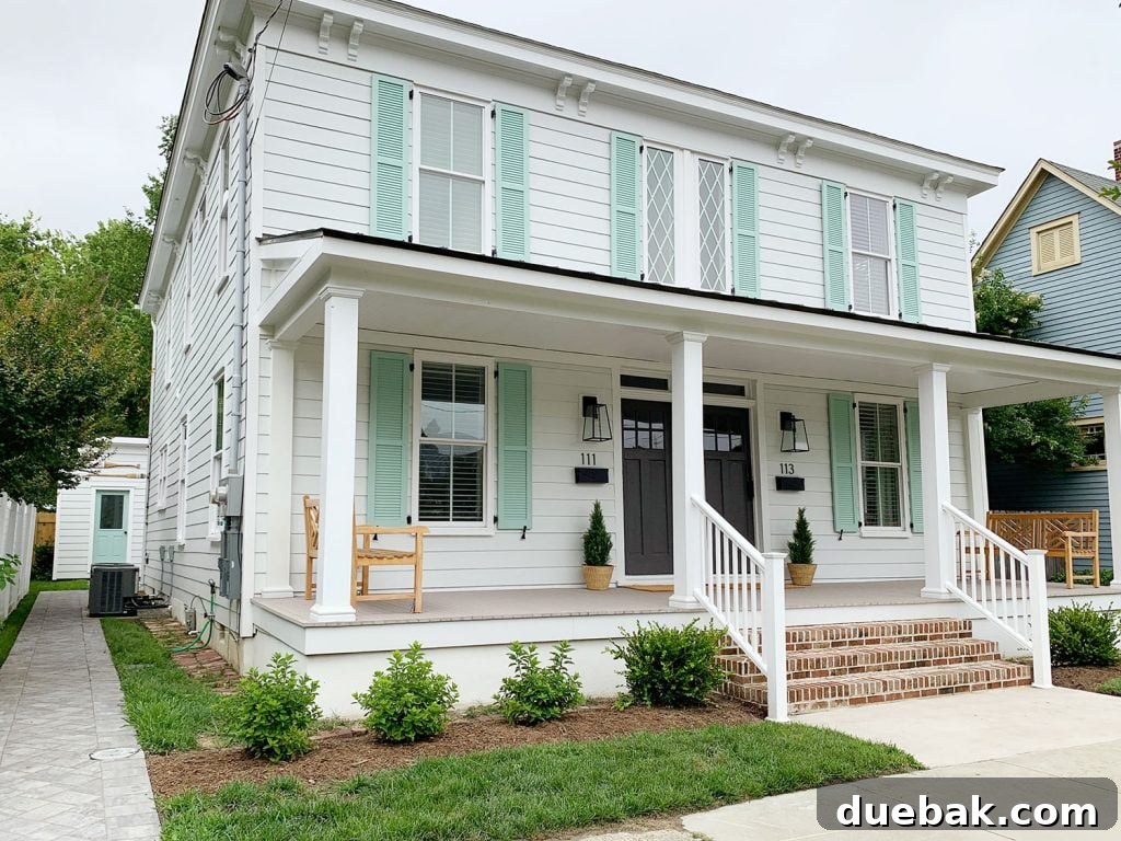 Celebratory front view of the fully renovated duplex, showcasing its new landscaping, refreshed exterior, and enhanced curb appeal.