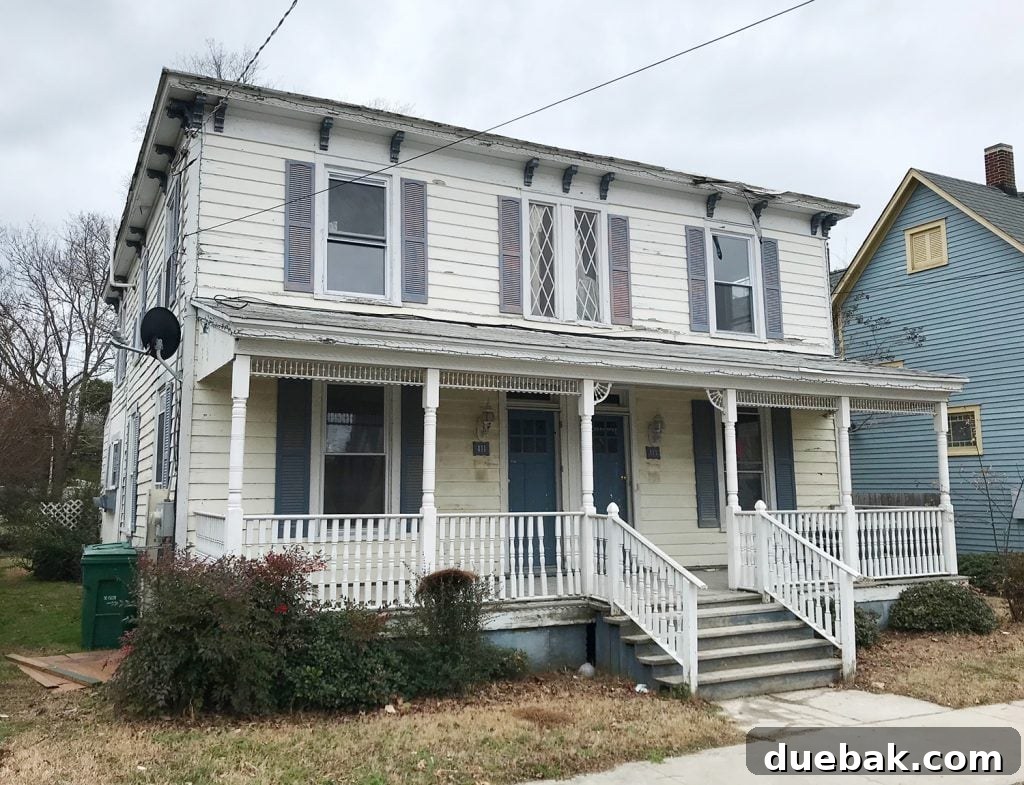 Original before photo of the duplex, highlighting its neglected state and lack of curb appeal prior to the extensive renovation.