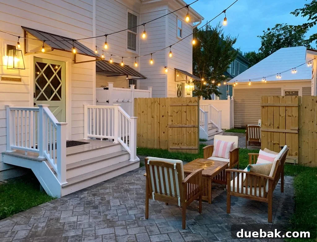 Detailed shot of the duplex backyard entrance featuring a stylish porch lantern, a clear address plaque, a secure keypad lock, and a protective awning over a back door painted Pale Patina.