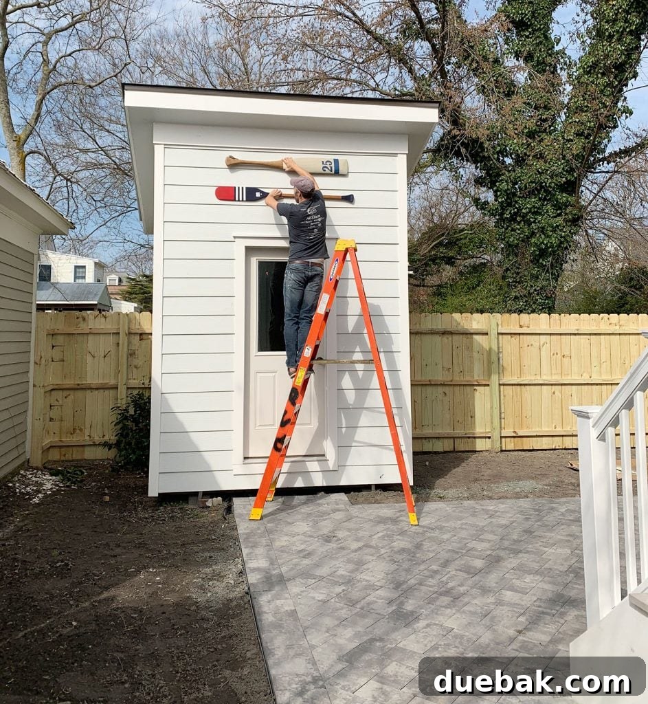 Two decorative oars held up against a shed to check size and fit
