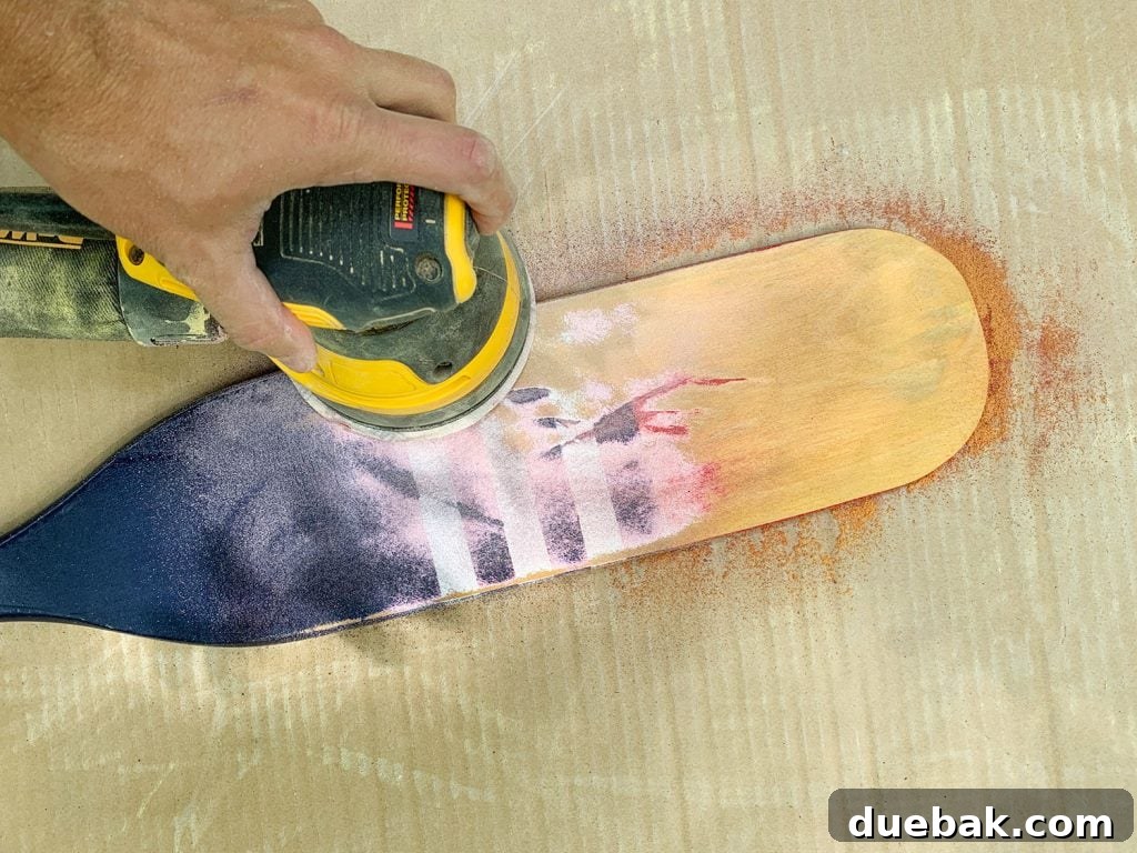 Orbital sander in action, sanding a decorative oar