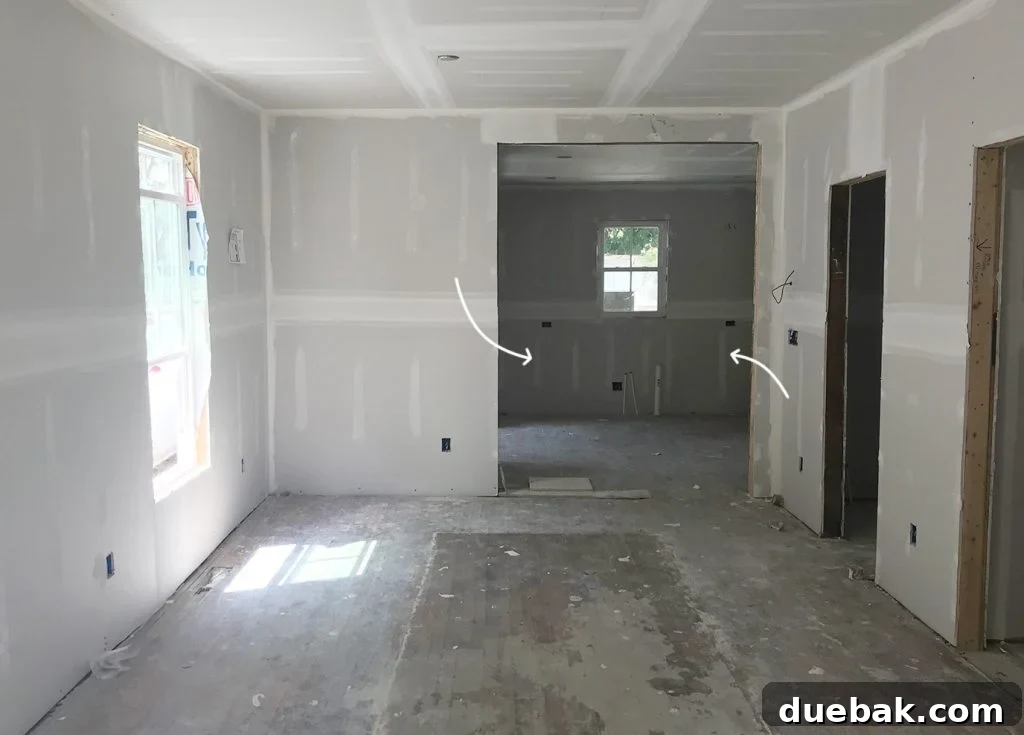 Unfinished Drywall In Duplex Renovation With Kitchen In Background