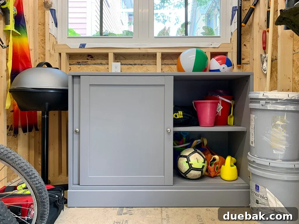 Taming the Beach House Shed 14 Open IKEA cabinet revealing organized toys, buckets, and garden gear