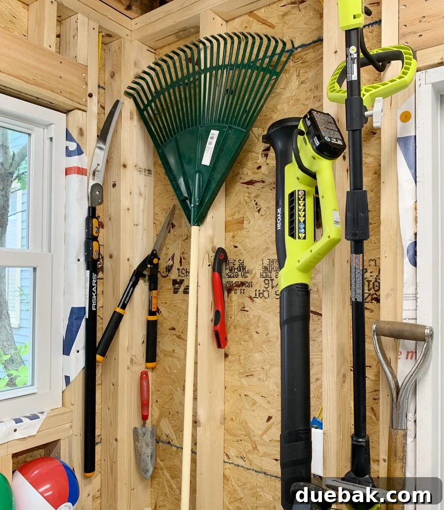 Taming the Beach House Shed 15 Wall with various garden tools hung on simple hooks and nails