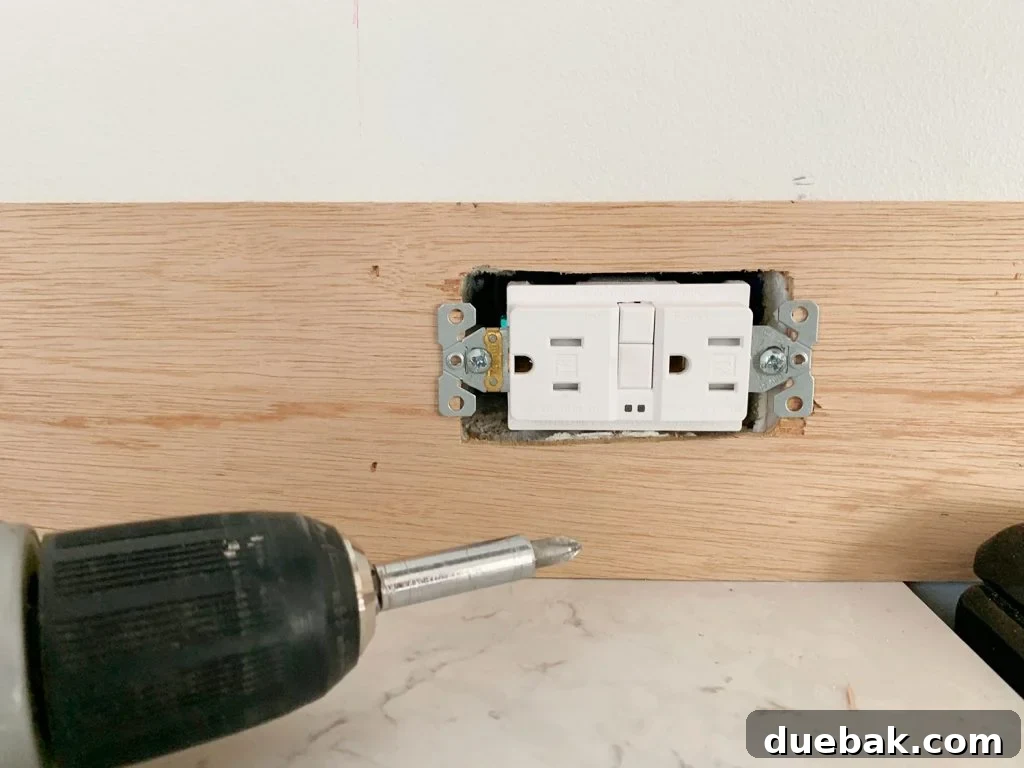 Electrical Outlet Screwed Back In Place Over Panel Strip
