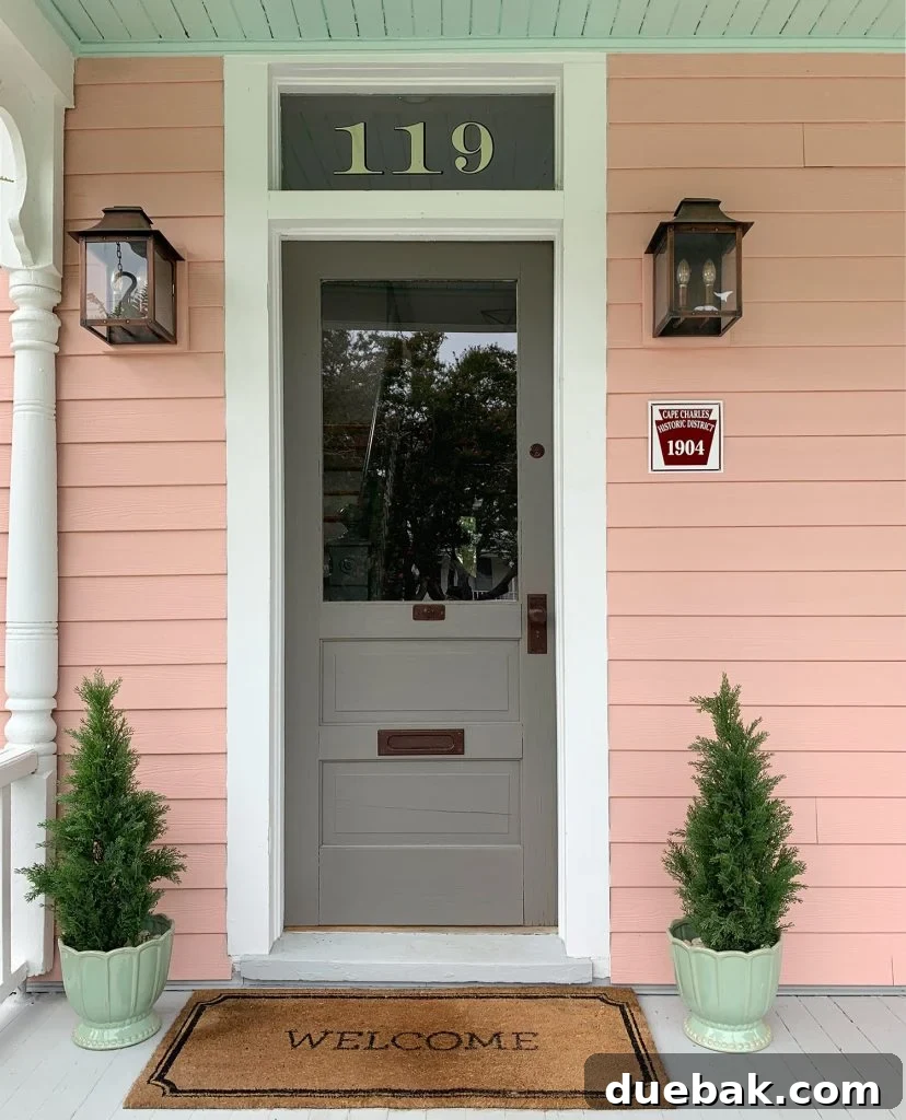 The Pink House Unveiling Its Unexpected History 10 Another view of the beach house entrance, emphasizing the door's details and the porch's welcoming ambiance.