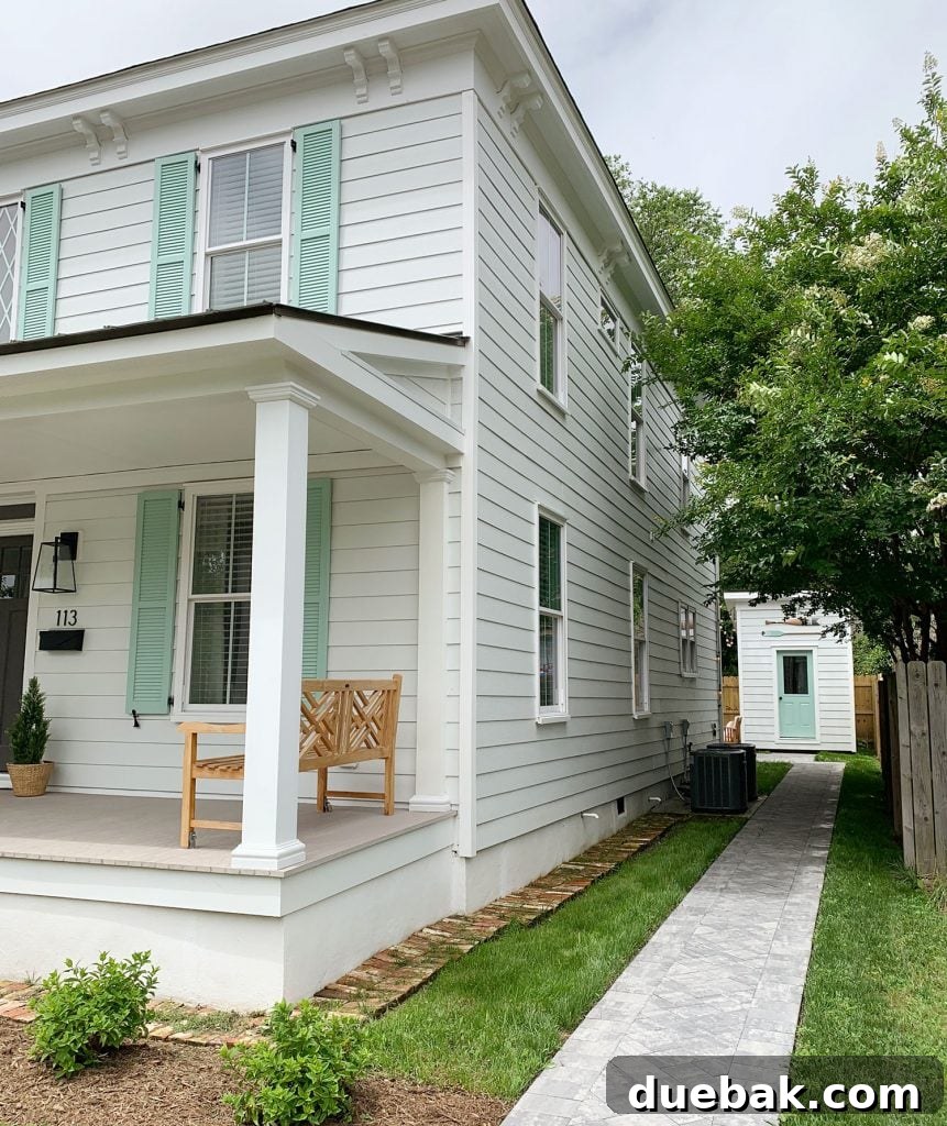 Exterior shot of a duplex, showcasing a porch and green shutters.
