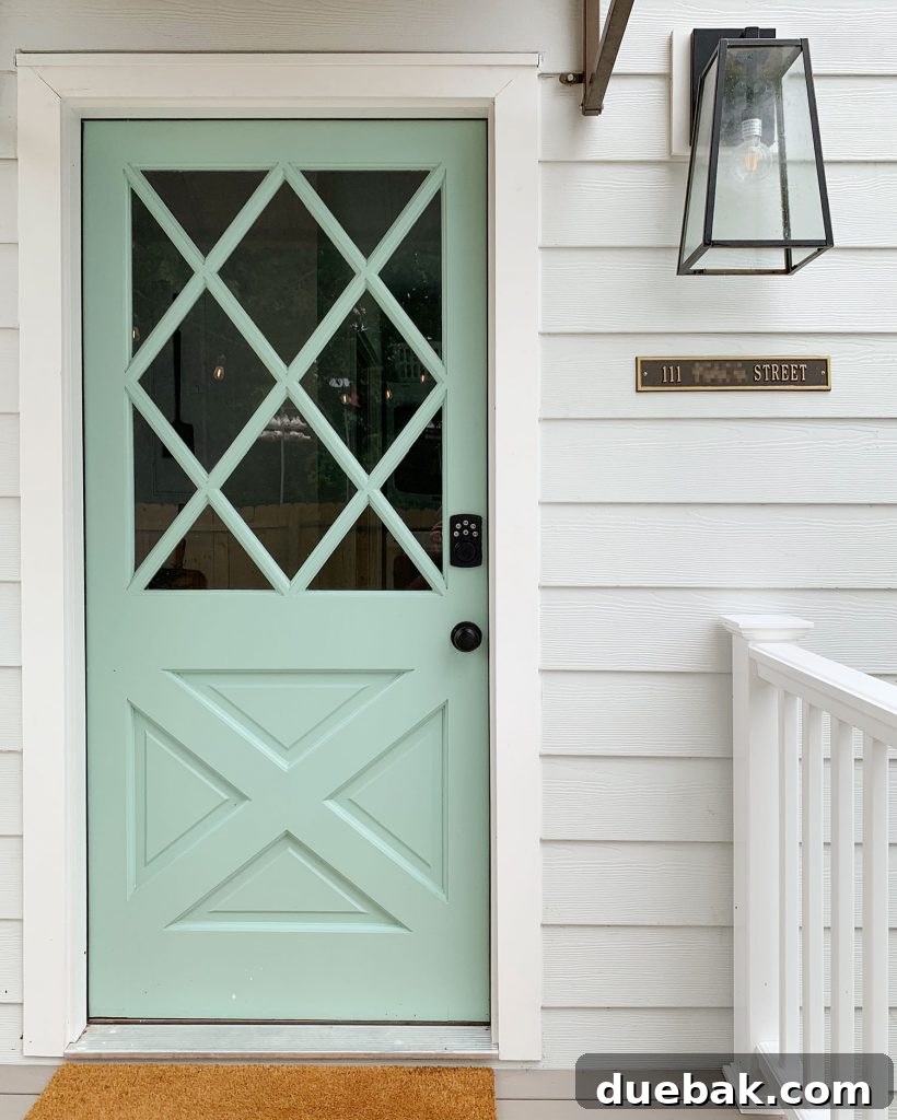 Close-up of a front door with a keypad lock and address plaque.