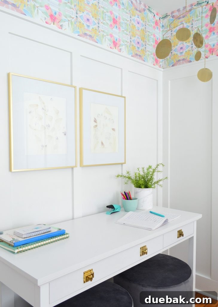 Textural Tides: Wallpaper and Board and Batten in a Beach Bedroom 7 White desk with gold hardware against a board and batten wall, adorned with brass frames and a mobile