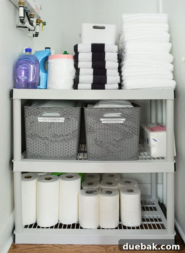 Duplex Owners Closet With Plastic Shelving Labeled Bins, neatly organized with extra towels and linens