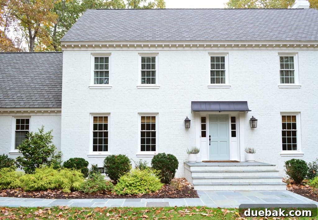 The new bluestone front path leading up to the white brick house, showcasing its elegant design and texture.