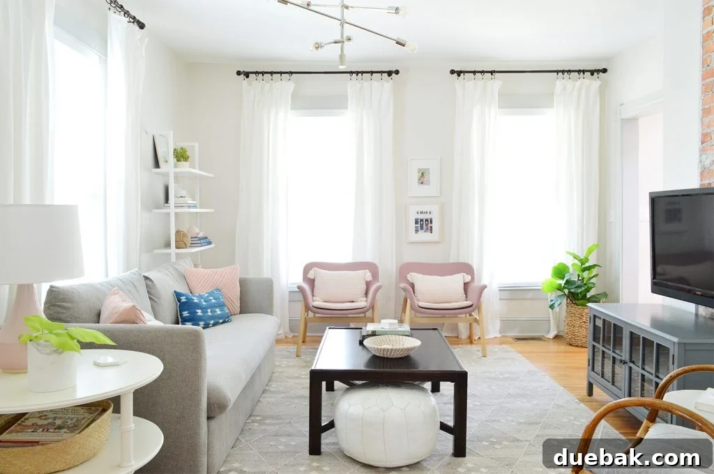 7 Beach House Renovations and the Story Behind Each Space 11 Beach house living room with comfortable pink chairs and a dark coffee table, showcasing a refreshed look