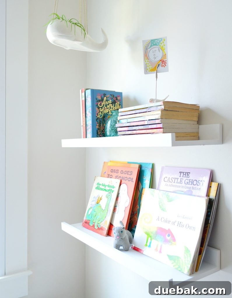 7 Beach House Renovations and the Story Behind Each Space 14 Floating bookshelves adorned with a hanging whale planter in a child's bunk room, offering practical storage
