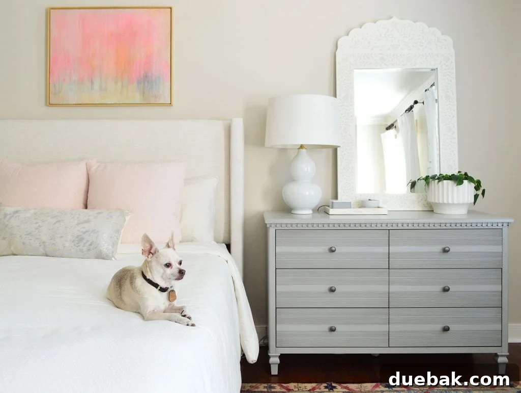 A beautifully appointed bedroom featuring a stylish dresser and a large stenciled mirror, creating a focal point in the room.