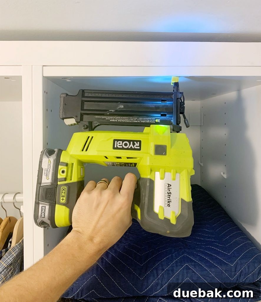 Close-up of the Ryobi AirStrike Nailer attaching the first board to an IKEA Pax unit for a built-in look.