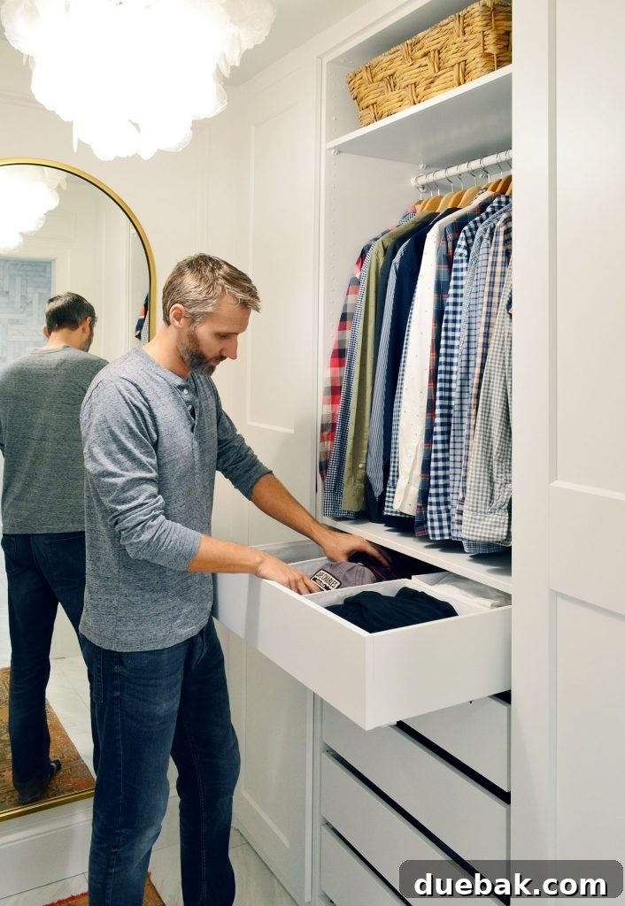 John retrieving clothes from a well-organized IKEA Pax drawer system on his side of the closet.