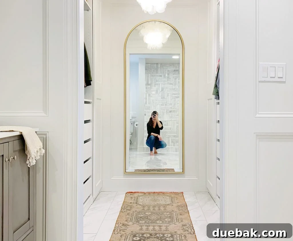 Major Duplex Updates 3 Sherry taking a selfie in a newly renovated master closet mirror, showcasing the organized space.