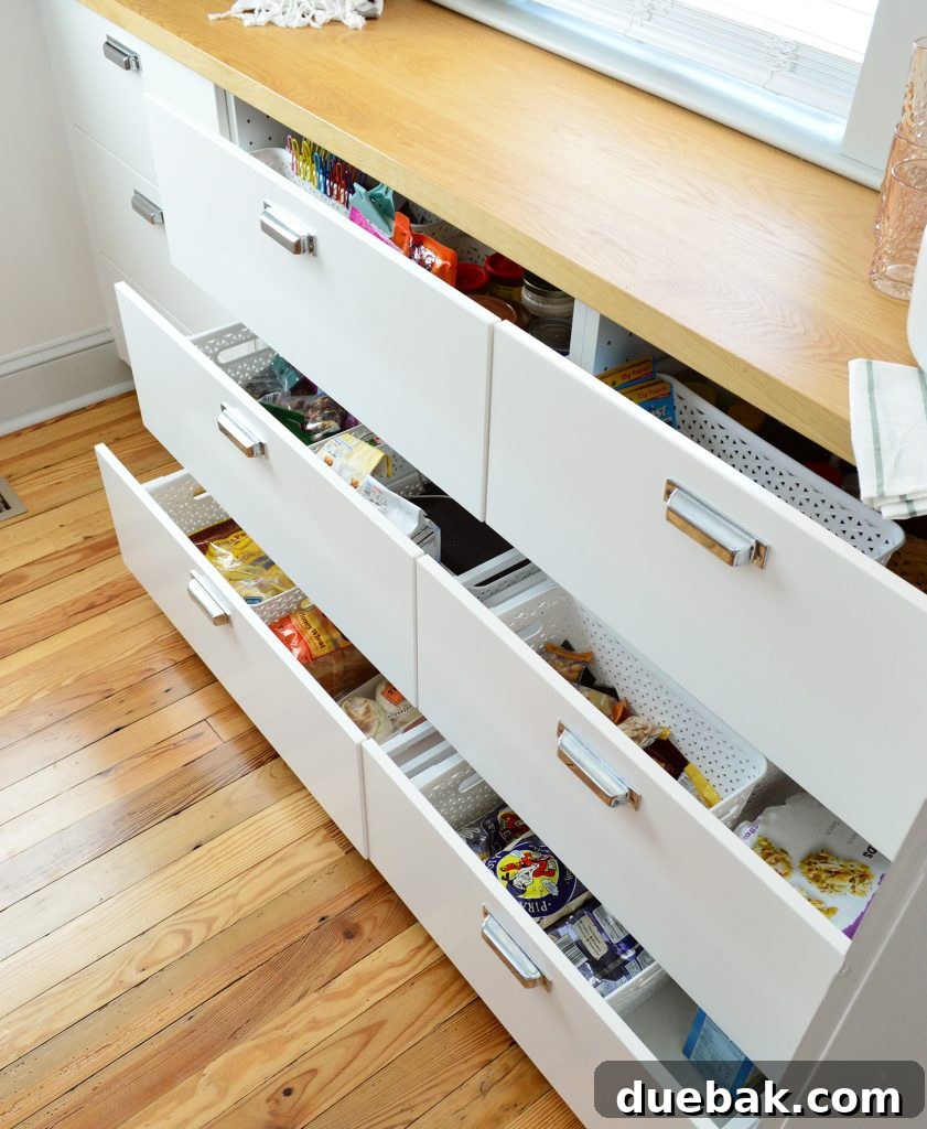 Pantry drawer organized with various food items in bins and containers