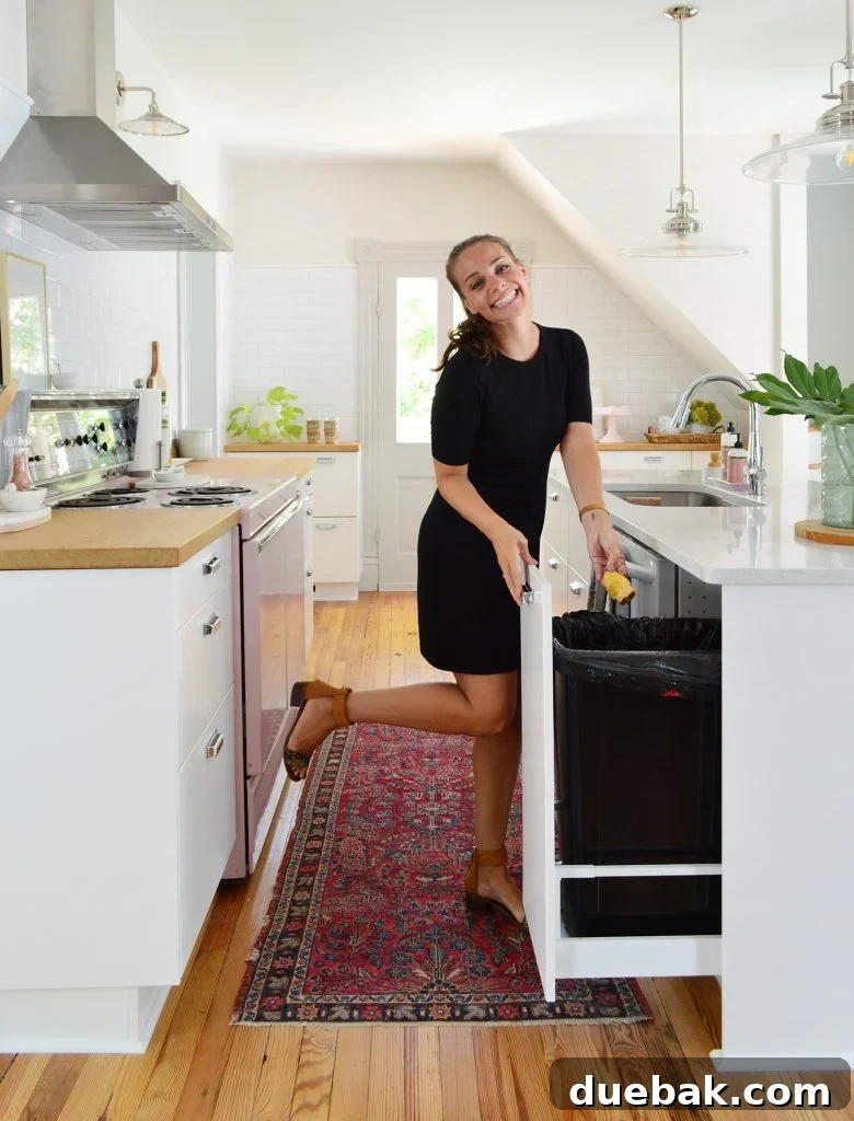 Kitchen island with a custom pullout trash can integrated into the cabinetry