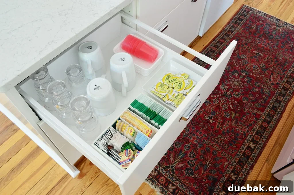 Kitchen drawer organized as a drink station with cups, mugs, and tea supplies