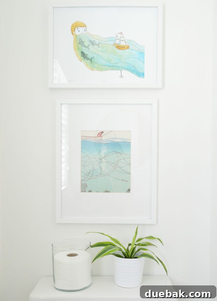 Ocean-Themed Art Above Toilet in Updated Bathroom
